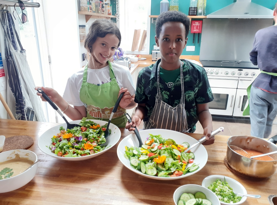 young people smiling with bowls of salad
