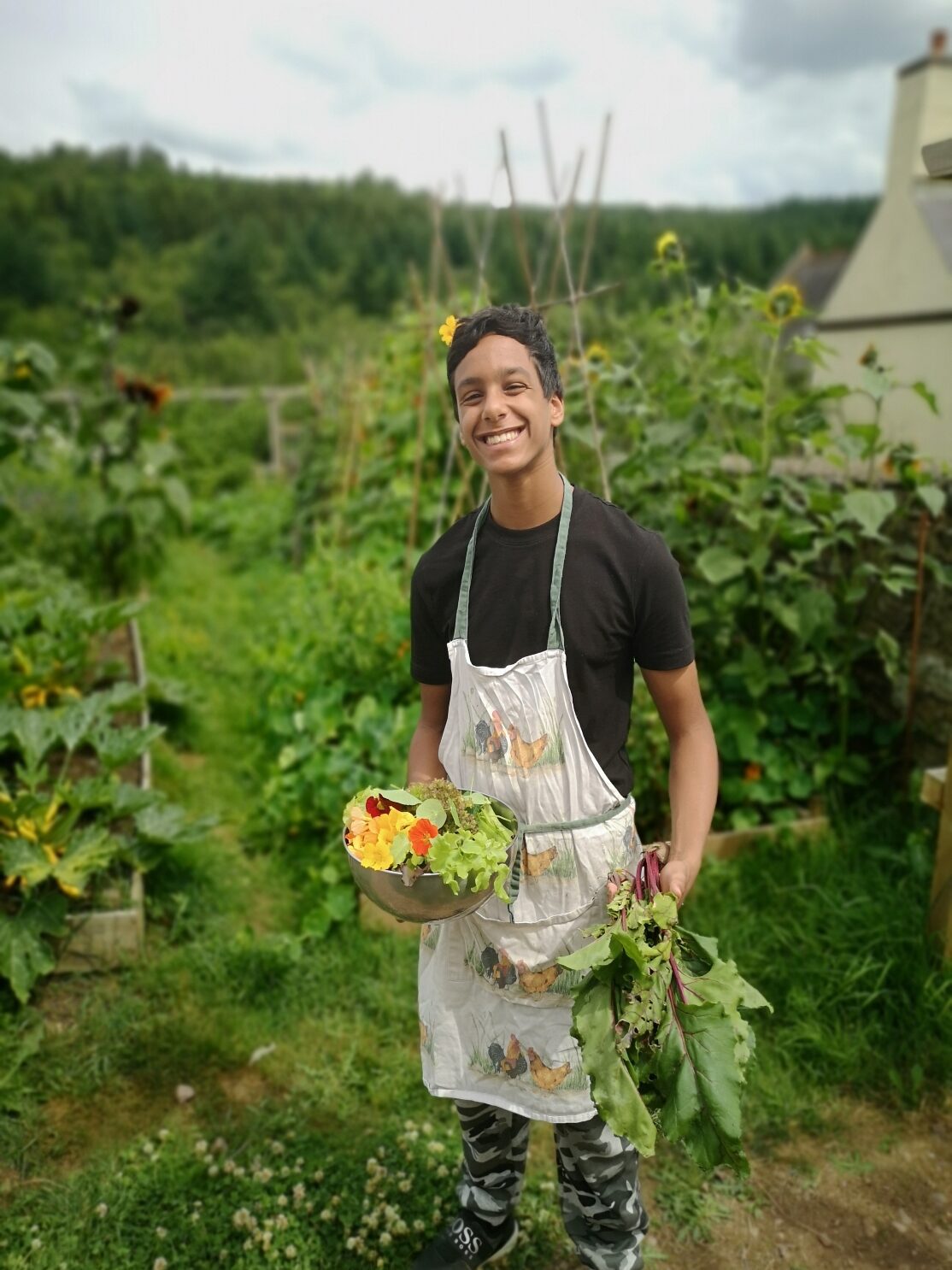 boy smiling with vegetables from the garden