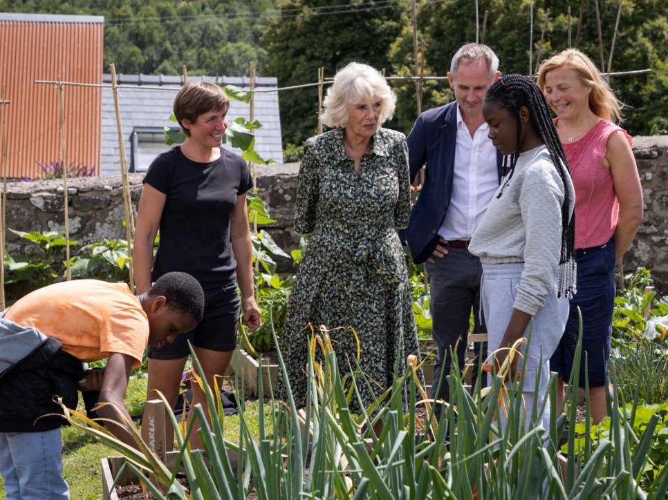 The Queen Consort joined by Jamie's Farm staff and young people in a spring-time vegetable garden
