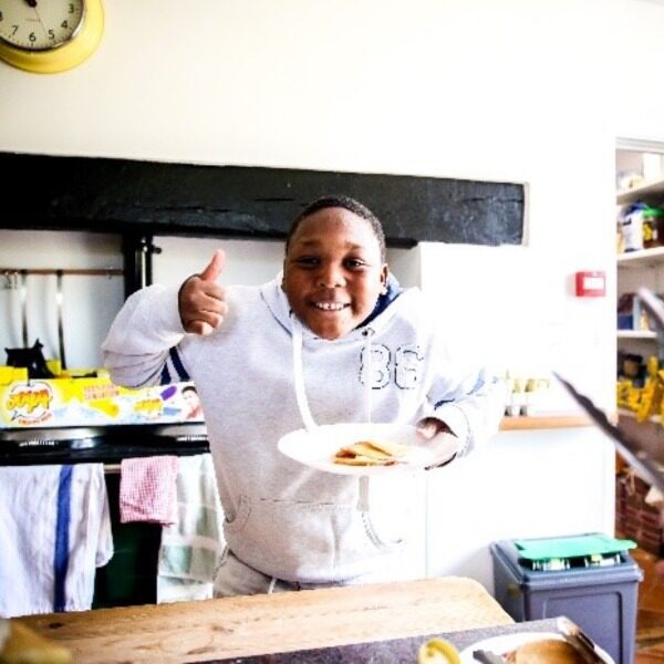 Boy in kitchen giving thumbs up