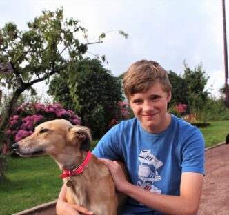 a young person smiling with a dog