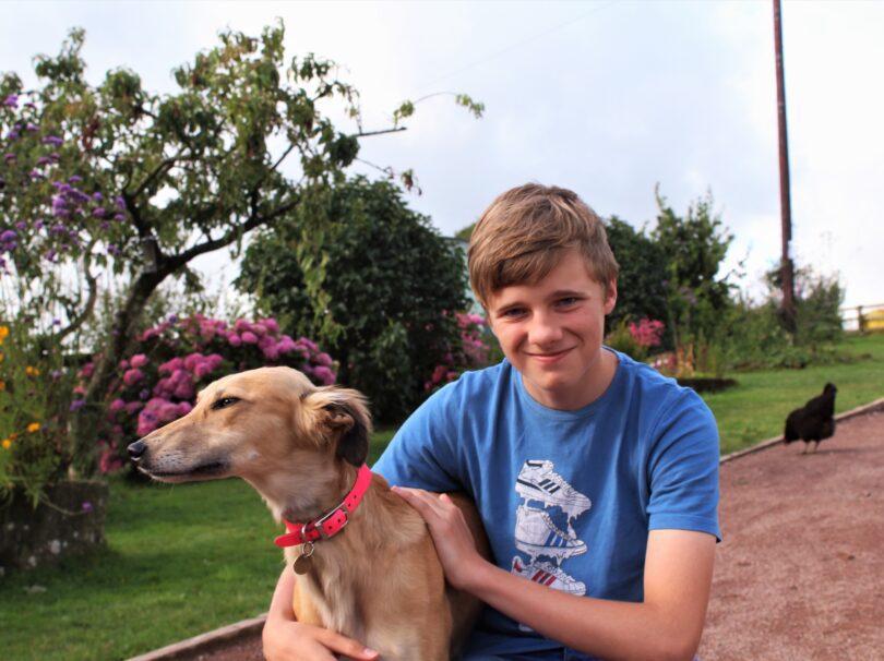 a young person smiling with a dog
