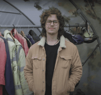 George wearing a think jacket standing in a polytunnel.