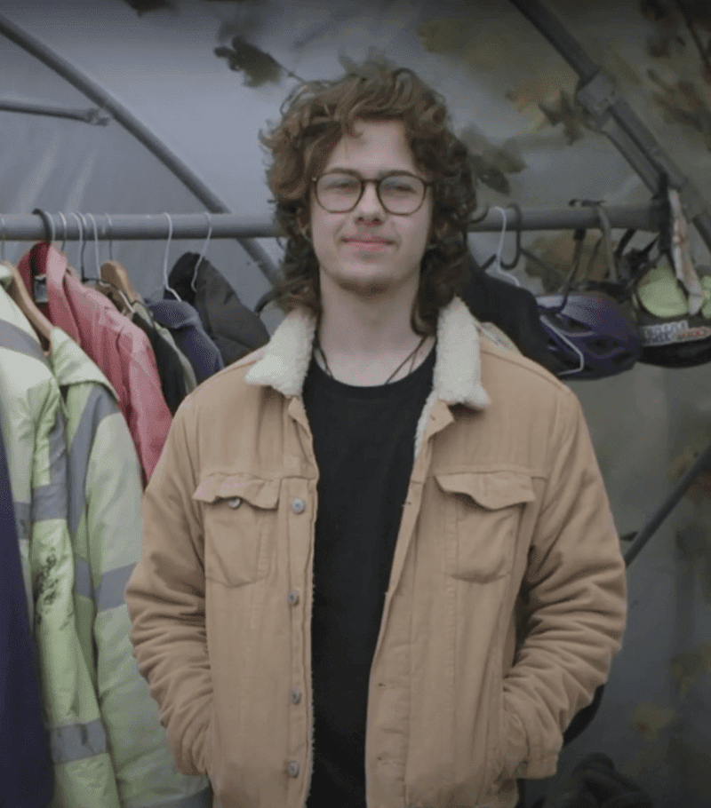 George wearing a think jacket standing in a polytunnel.