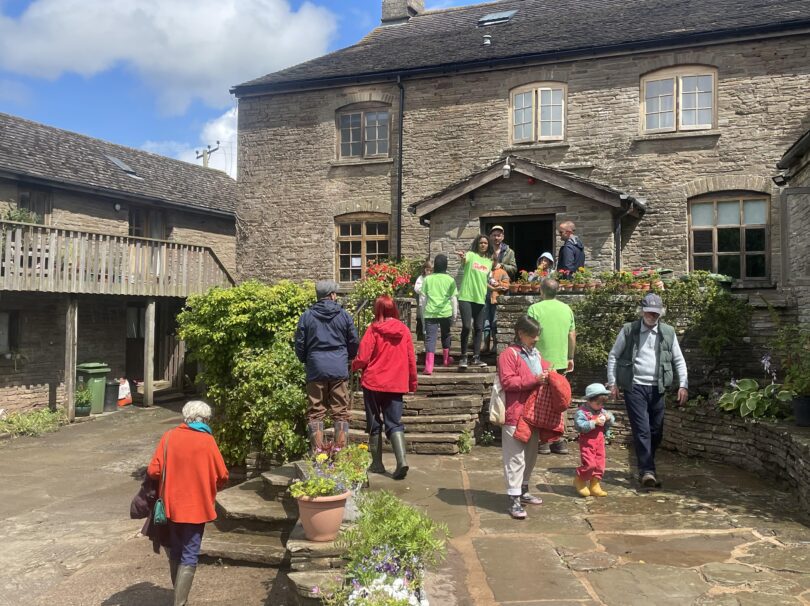 People walking up into a farmhouse