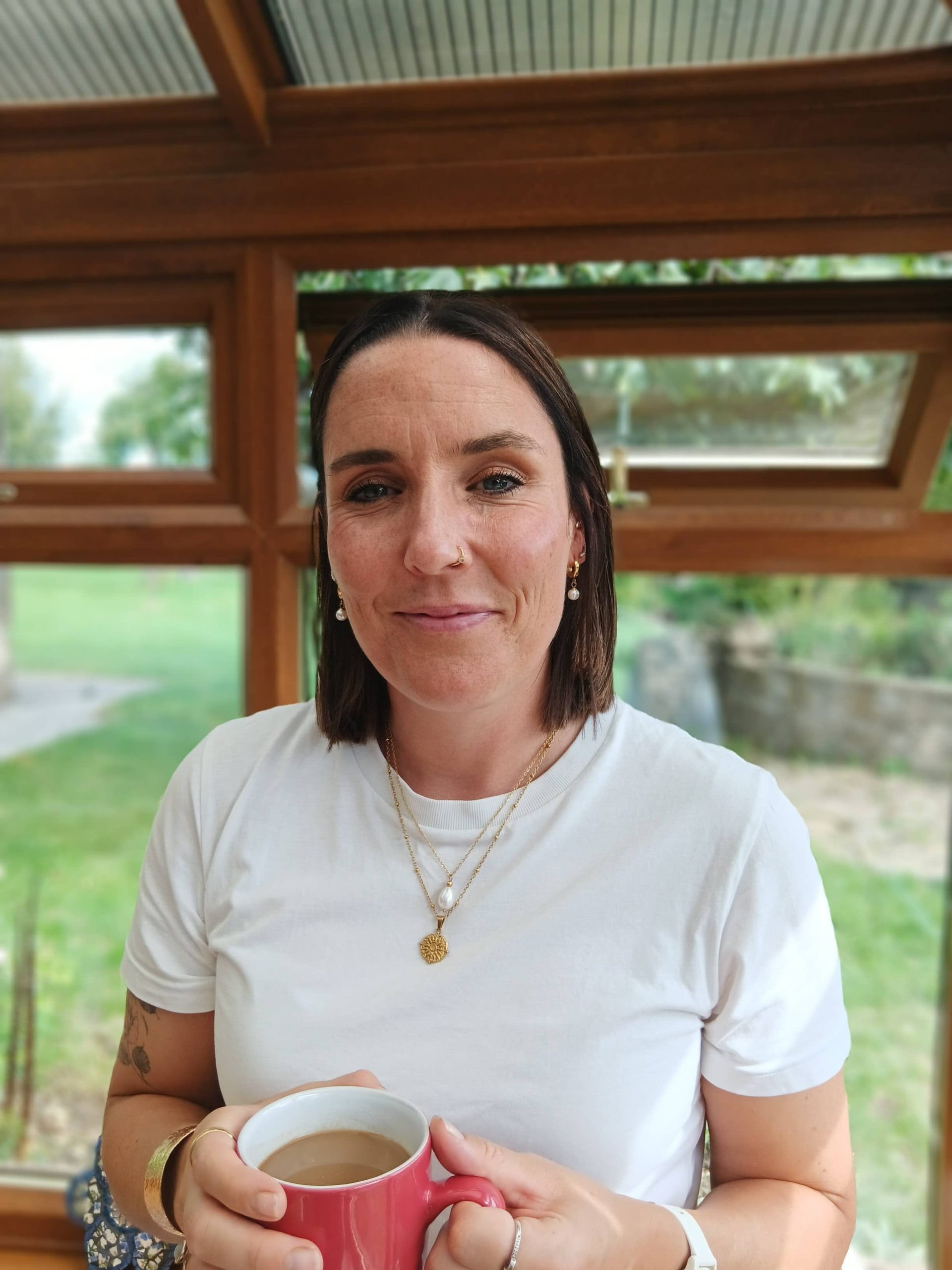 A photo of Laura, smiling in the conservatory at Jamie's Farm HQ. 