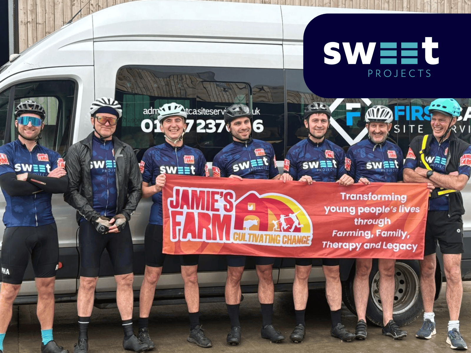 A group of employees from ADM standing in front of a minibus, wearing cycling gear and holding a Jamie's Farm banner.