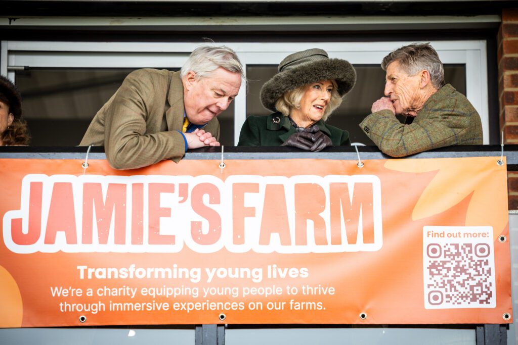 Her Majesty The Queen watching the racing with two other people
