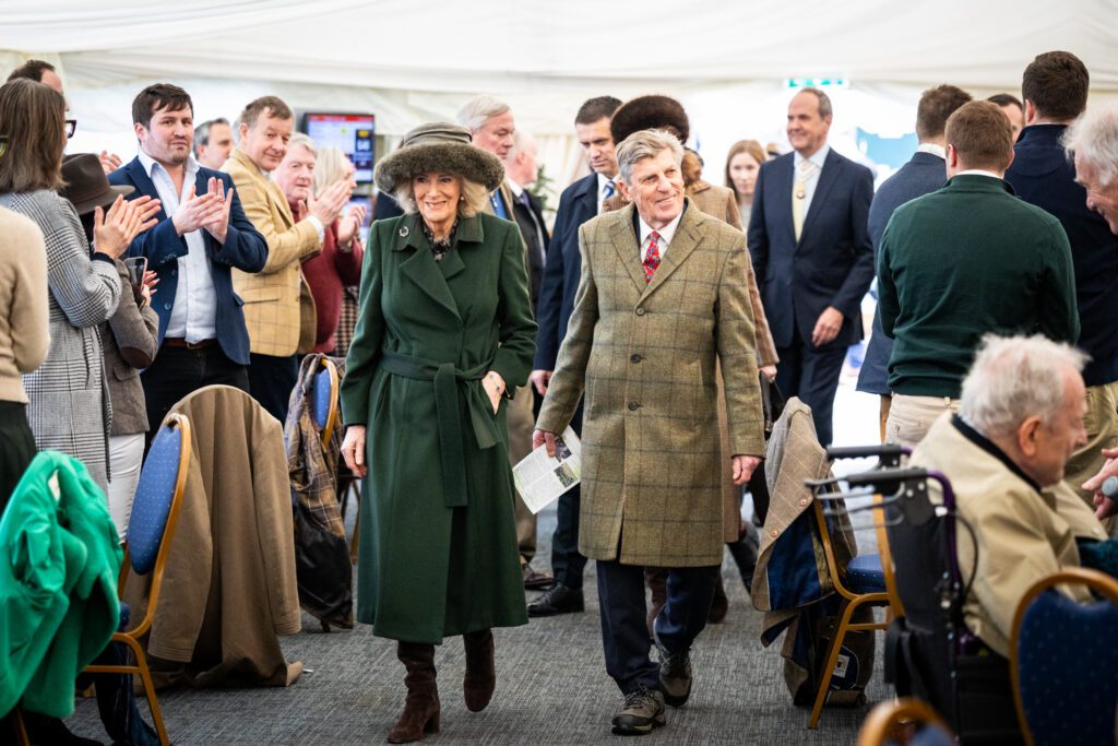 Her Majesty and Brough Scott walking with people clapping in the background