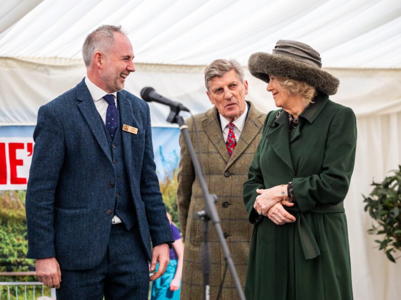 Jamie Feilden and Her Majesty speaking on stage