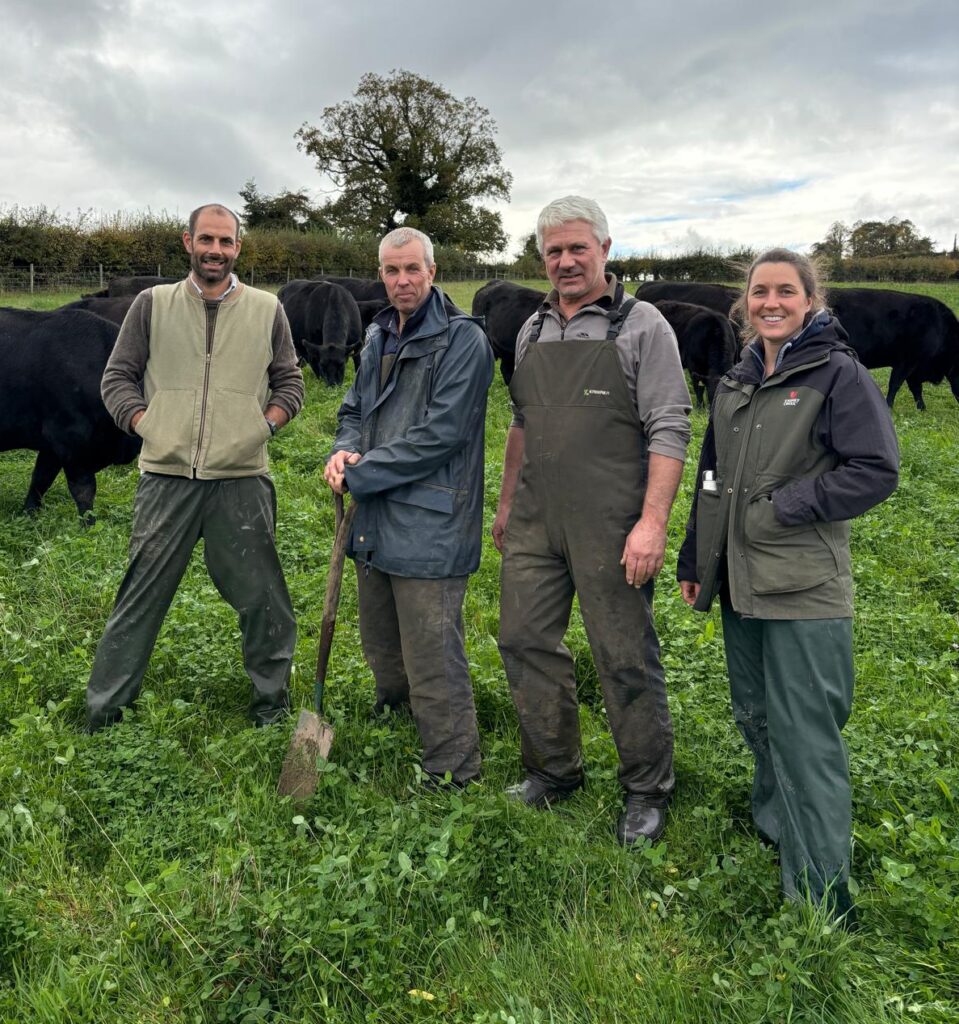 3 members of the farming team at the Bath farm working with Tim Williams, soil expert in a field